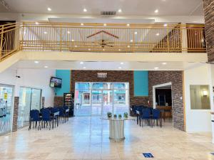 a lobby with chairs and a table and a staircase at B&J HOTEL AND APARTMENTS in Pecos