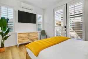 a white bedroom with a large bed and a tv at Indio Access Vacation Home in Indio +13 photos