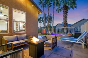 a patio with a couch and chairs and a fire pit at Indio Access Vacation Home in Indio