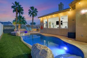 a swimming pool in front of a house at Indio Access Vacation Home in Indio