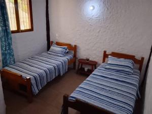 two beds sitting next to each other in a room at El Refugio II, cerca Playa El Agua y Playa Parguito, VENEZUELA in Loma de Guerra
