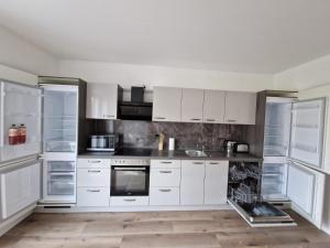 a kitchen with white cabinets and stainless steel appliances at Monteurwohnung RoomWork24 - 10 Betten - Twistringen in Twistringen