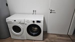 a washer and dryer in a room next to a door at Monteurwohnung RoomWork24 - 10 Betten - Twistringen in Twistringen