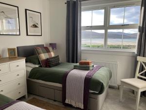 a small bedroom with a bed and a window at Taigh Marsaili in Luskentyre
