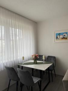 a dining room with a table with chairs and a vase of flowers at Bella stan na dan in Široki Brijeg