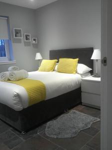 a bedroom with a large bed with yellow pillows at Portree But & Ben in Portree