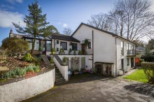 a white house with a driveway at Meadfoot Guesthouse Room only accommodation for Adults in Windermere