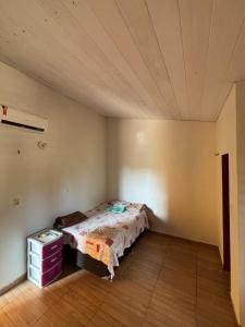 a bedroom with a bed and a dresser in it at Pousada Raios do Sol in Amontada