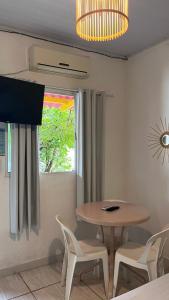 a dining room with a table and chairs and a rainbow window at Pousada Suítes Sete Mares in Guarujá +57 photos