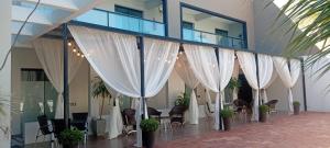 a room with white curtains and chairs and tables at Pousada São Gerônimo in Matinhos
