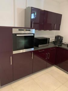 a kitchen with purple cabinets and a stove and microwave at Wohnung zur Langzeitmiete geeignet in Bad Kreuznach