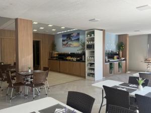 a restaurant with tables and chairs and a bar at Pousada São Gerônimo in Matinhos