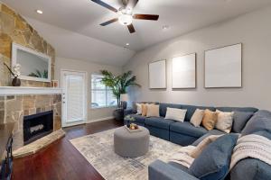 a living room with a blue couch and a fireplace at Games, Backyard & Patio: Spacious Home in Frisco in Frisco