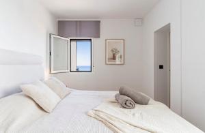 a bedroom with a white bed with towels on it at Villa Perdices in Fuengirola