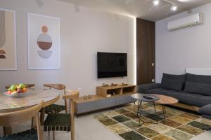a living room with a couch and a table at Estia Luxury Apartment in Ierapetra
