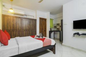 a bedroom with a bed and a flat screen tv at Hotel O RR in Kondapur
