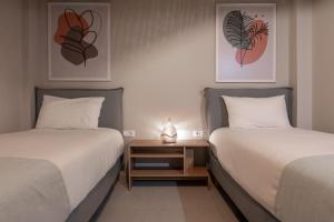 two beds sitting next to each other in a room at Estia Luxury Apartment in Ierapetra