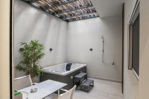 a room with a tub and a table and chairs at Estia Luxury Apartment in Ierapetra +91 photos