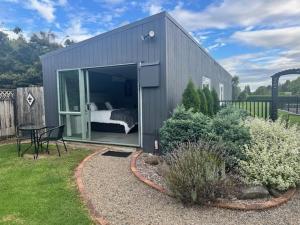 a small gray house with a bed and a table at Thornton Hideaway Private Standalone Retreat, Walk to Cambridge Town Centre in Cambridge