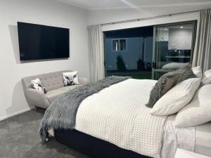 a bedroom with a large bed and a couch at Thornton Hideaway Private Standalone Retreat, Walk to Cambridge Town Centre in Cambridge
