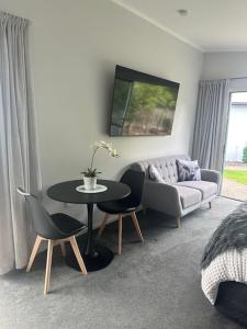 a living room with a couch and a table with chairs at Thornton Hideaway Private Standalone Retreat, Walk to Cambridge Town Centre in Cambridge