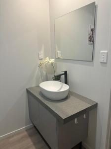 a bathroom with a white sink and a mirror at Thornton Hideaway Private Standalone Retreat, Walk to Cambridge Town Centre in Cambridge +5 photos