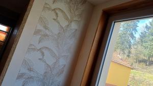 a wall paper with a palm tree pattern on a window at OAK Familly in Saint-Racho +4 photos