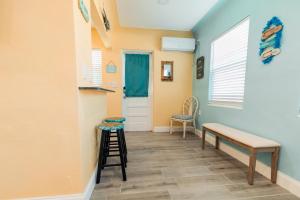 a hallway with a bench and a stool and a door at Gorgeous Beach Condo in St. Petersburg
