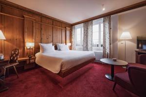 a hotel room with a large bed and a chair at YONA ex Le Parc Hôtel in Obernai +50 photos