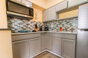 a kitchen with white cabinets and a microwave at Gorgeous Beach Condo in St. Petersburg