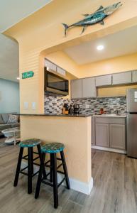 a kitchen with two bar stools and a shark on the ceiling at Gorgeous Beach Condo in St. Petersburg