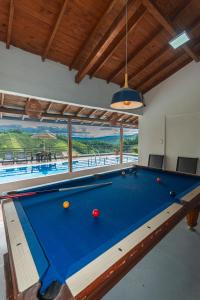 a pool table in a living room with a view at Hotel Casa Encanto in Doradal