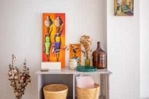 a console table with vases and paintings on the wall at Alma de San Bernardo in Seville