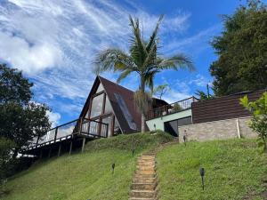 a house on top of a hill with a palm tree at Finca Hotel Mariangel in El Peñol