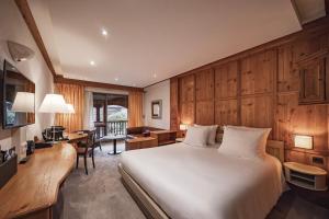 a bedroom with a large white bed and a desk at YONA ex Le Parc Hôtel in Obernai