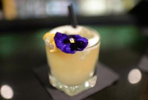 a drink with a purple flower on top of it at Stanhill Court Hotel, a member of Radisson Individuals in Horley