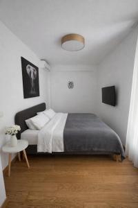 a white bedroom with a bed and a table at Libertina Rafailovici in Rafailovici