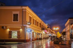 a city street at night with a rainy at NOMA Boutique Hotel in Shkodër