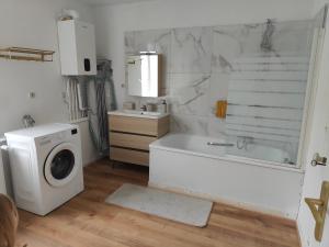 a bathroom with a washing machine and a bath tub at Prestige Loft-Cinéma Privé-King Size-Parking Gratuit-5 min Aéroport Beauvais in Beauvais