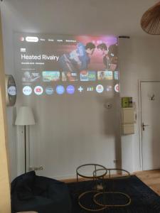 a large screen on a wall in a room at Prestige Loft-Cinéma Privé-King Size-Parking Gratuit-5 min Aéroport Beauvais in Beauvais +6 photos