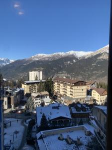 a city with snow covered buildings and mountains in the background at Studio Seguret in Sauze d'Oulx