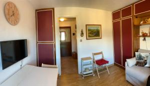 a living room with a couch and a tv at Studio Seguret in Sauze d'Oulx