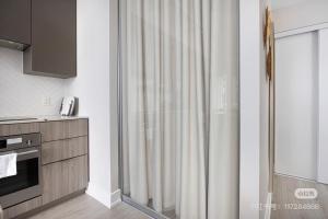 ein Badezimmer mit Duschvorhang in einer Küche in der Unterkunft KK Hotel in Markham