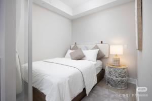 ein weißes Schlafzimmer mit einem Bett und einer Glastür in der Unterkunft KK Hotel in Markham