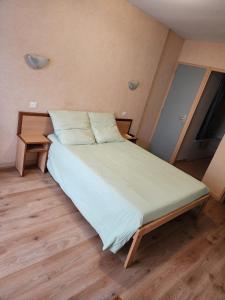 a large bed in a room with a wooden floor at La Bona Taula By A&J in Rochefort-Montagne