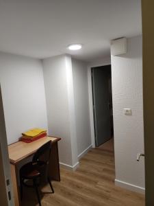 a room with a desk and a chair and a door at La Bona Taula By A&J in Rochefort-Montagne