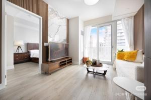 ein Wohnzimmer mit Fernseher und großem Fenster in der Unterkunft KK Hotel in Markham