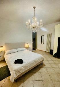 a bedroom with a large bed and a chandelier at Mordano Apartment - ampio appartamento SELF CHECK-IN vicino a Imola in Mordano