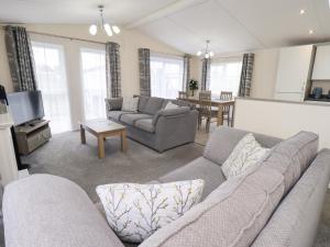 a living room with two couches and a table at Lily's Lodge in Morecambe