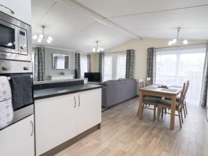 a kitchen and dining room with a table and a kitchen and a living room at Lily's Lodge in Morecambe